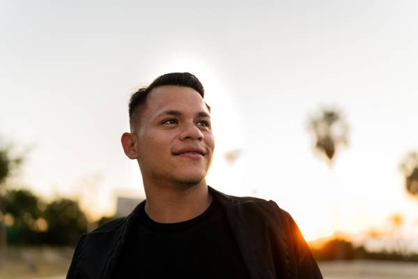 夕暮れの光の中で遠くを見つめる人物。希望や人生の意味を考える瞬間を表している